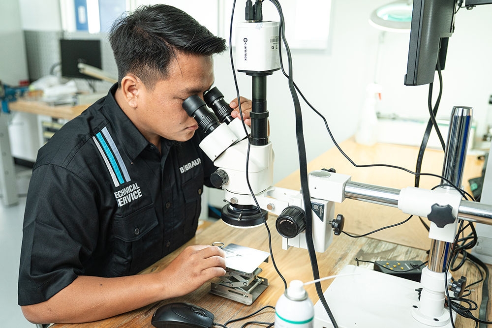 Female employee of  the Aesculap Technical Service repairs a surgical instrument