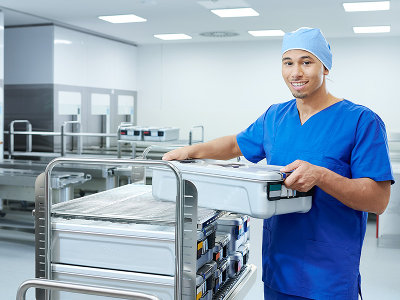 A male healthcare professional is holding a huge container smiling